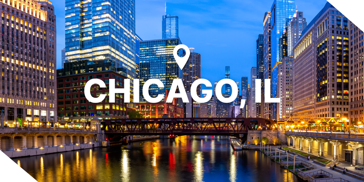 Chicago, Illinois skyline at dusk with bright lights from the real estate properties are reflecting in the water.
