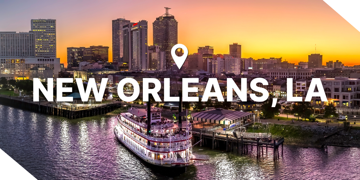 A sunset view of New Orleans, Louisiana with a riverboat and real estate properties on the water.