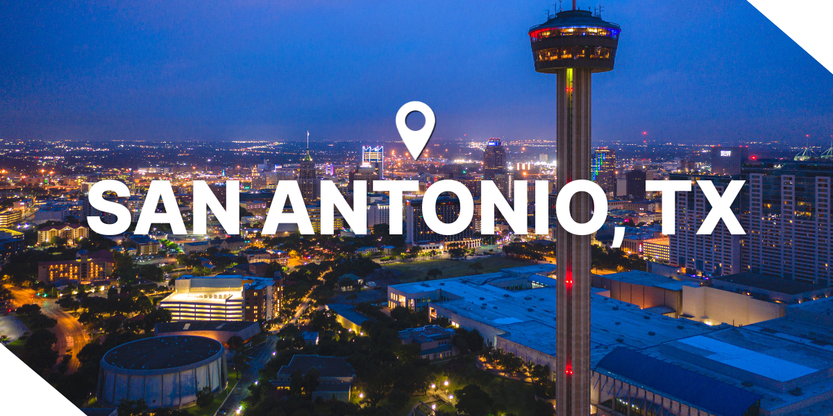 Night view of San Antonio, Texas, showcasing the Tower Life and bright real estate city lights.