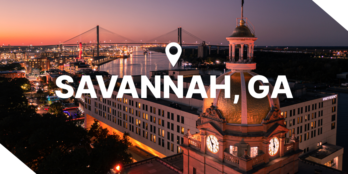 Night view of Savannah, Georgia, showing the river, bridge, real estate properties and city buildings.