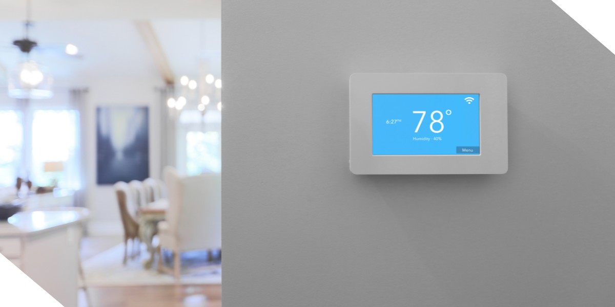 A sleek digital thermostat on a light gray wall, showcasing smart technology upgrades. Adding modern features like this to a fix-and-flip property boosts efficiency and can significantly increase ROI.