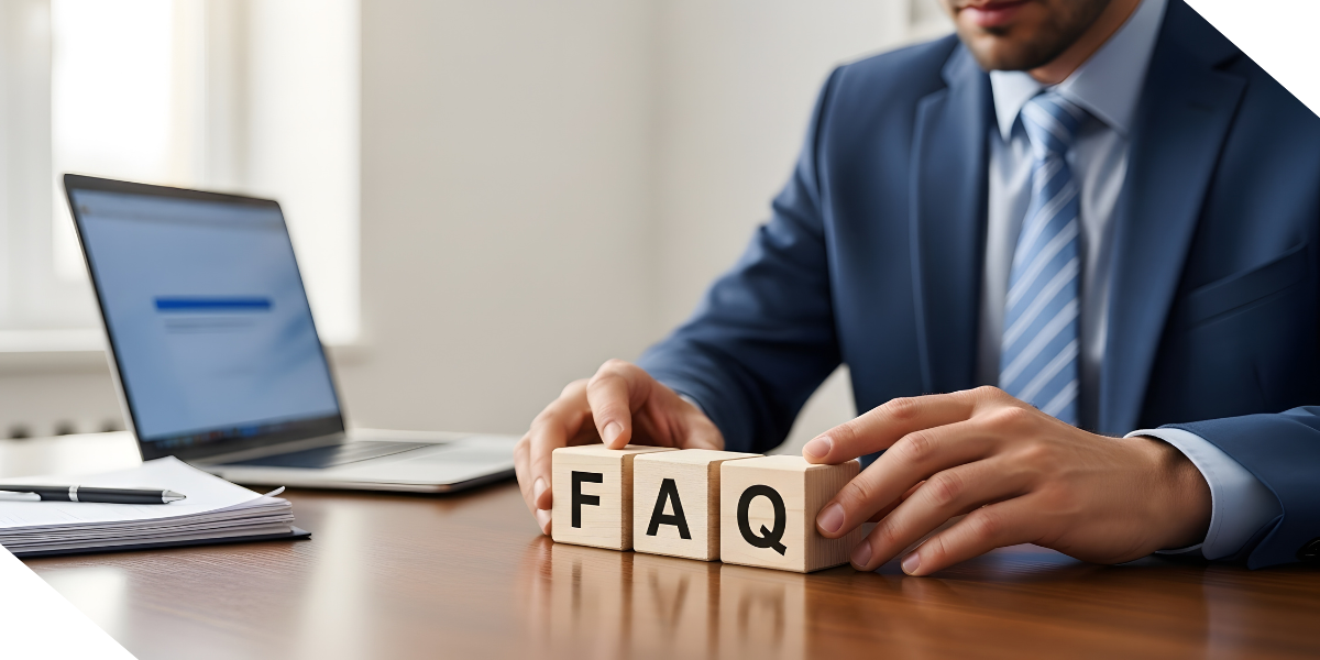A professional real estate agent in a blue suit arranges wooden blocks that spell "FAQ" on a desk next to a laptop and documents.