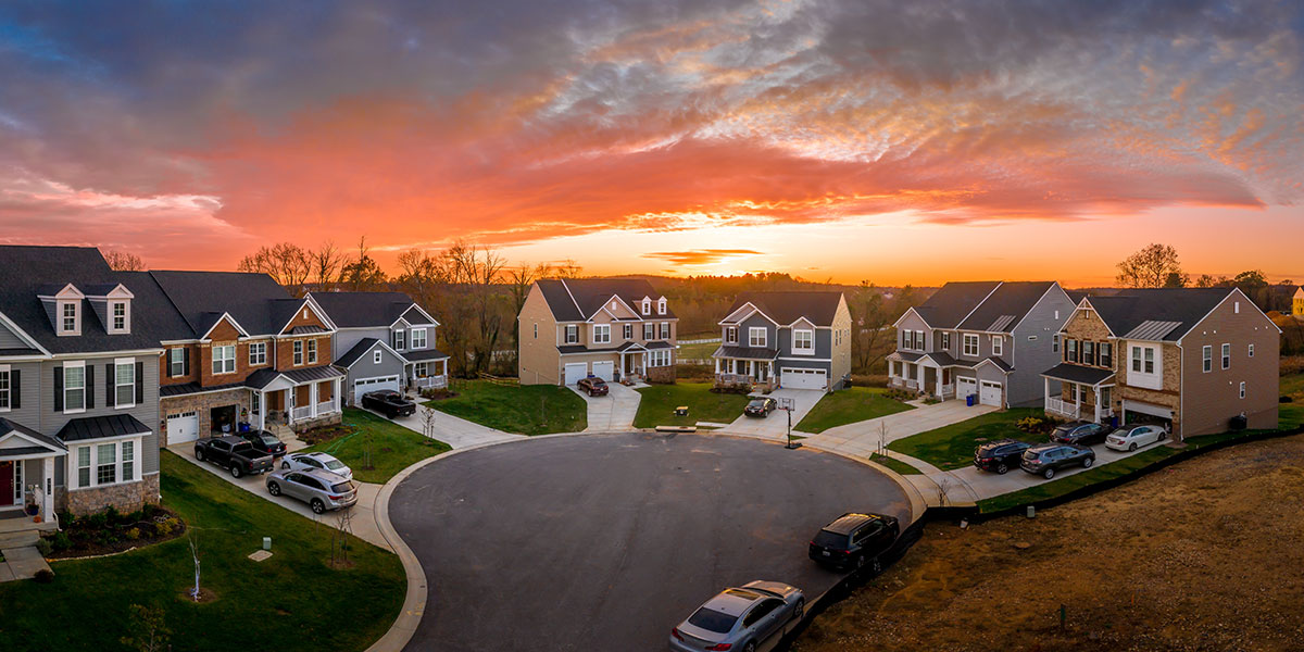 A cul-de-sac of homes at sunset that are real estate investing properties