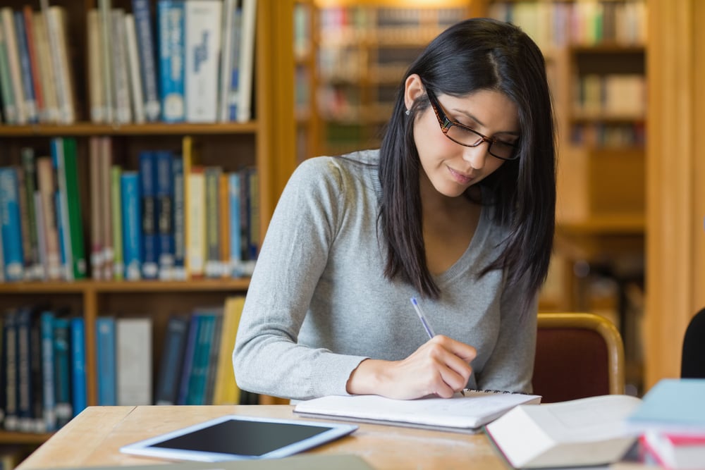 Black-haired woman studying in the library.