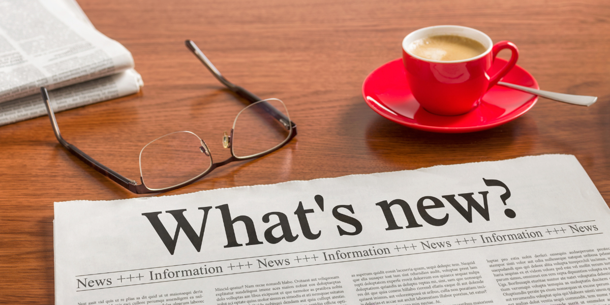 Newspaper reading What's New on a desk for Kiavi real estate market trends and financing updates.
