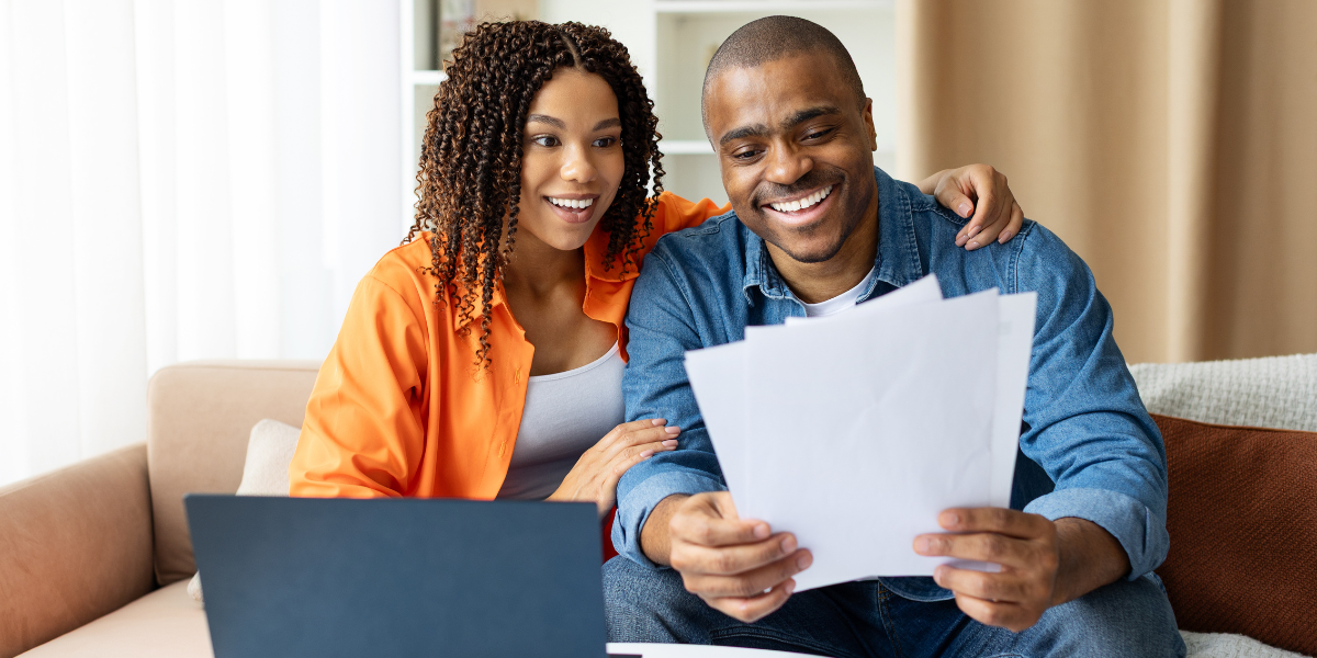 Smiling couple reviewing Kiavi real estate investment financing documents.
