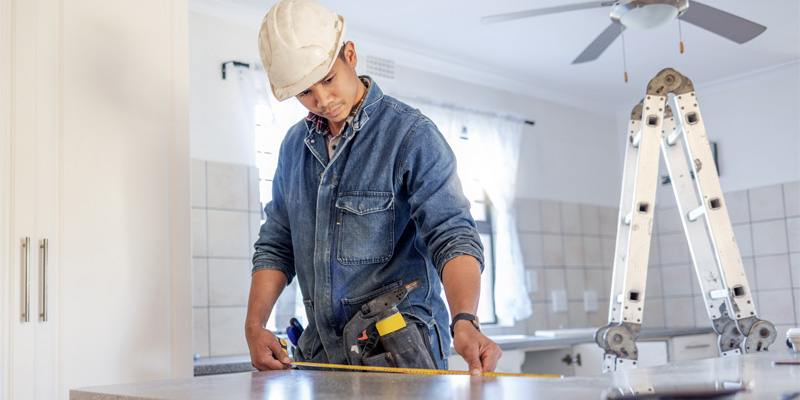 real estate investor measuring counter in a fix and flip property