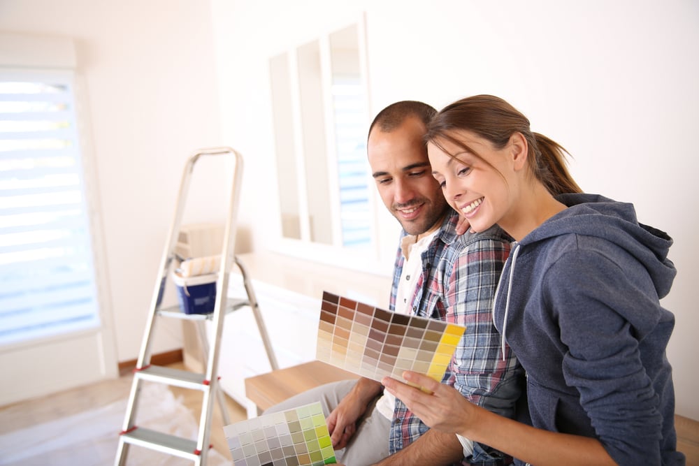 Couple in new house choosing color for walls for house flip project