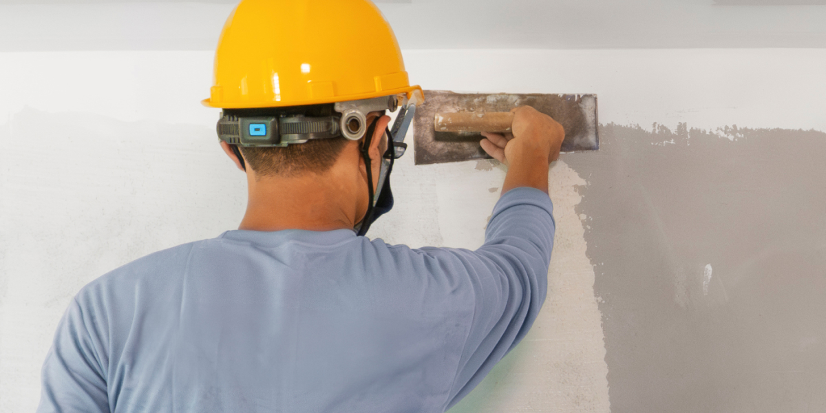 close up of a real estate investor putting up drywall
