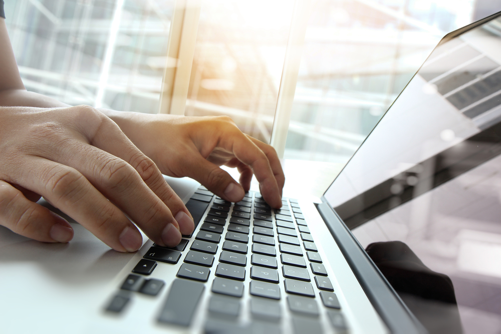 A closeup of hands typing on a laptop looking up types of financing.