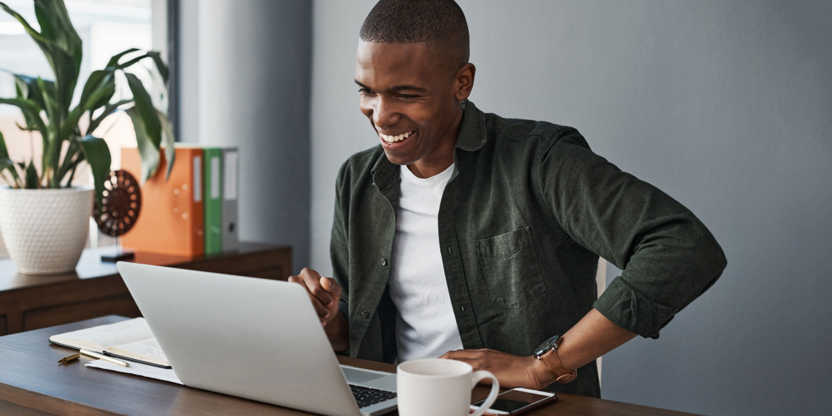 happy real estate agent reading on his laptop