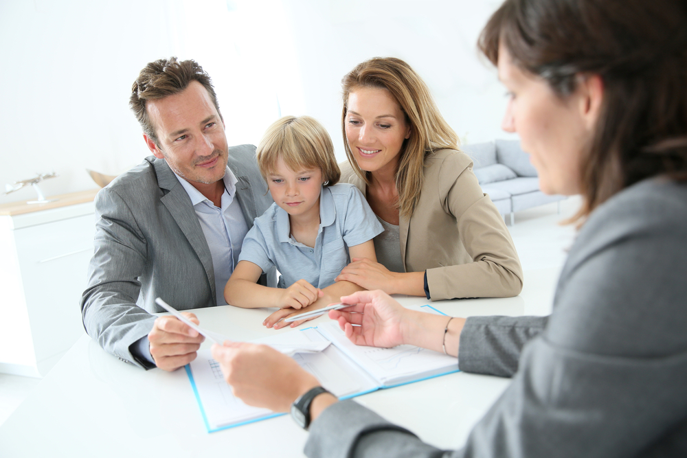A loan officer working with a family and going over paperwork.