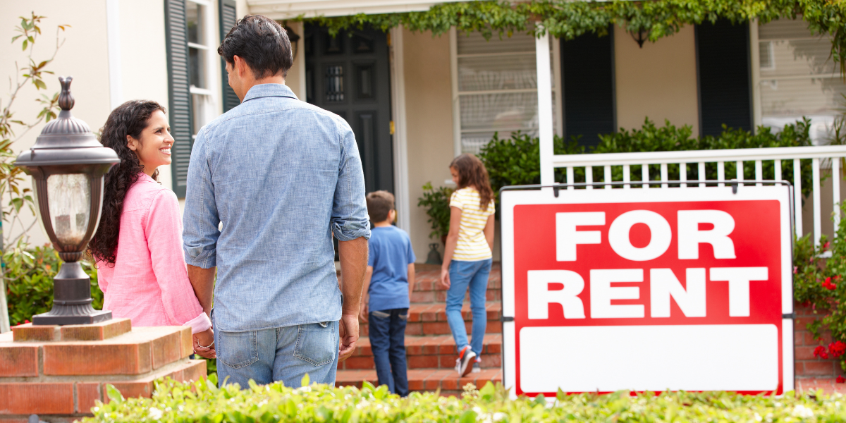 A real estate investor showing a rental property to a family.