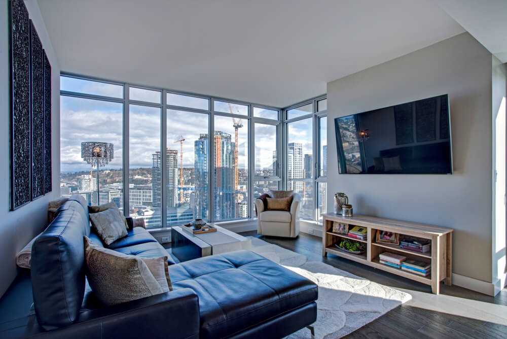 A picture of a highrise condo living room overlooking a city.