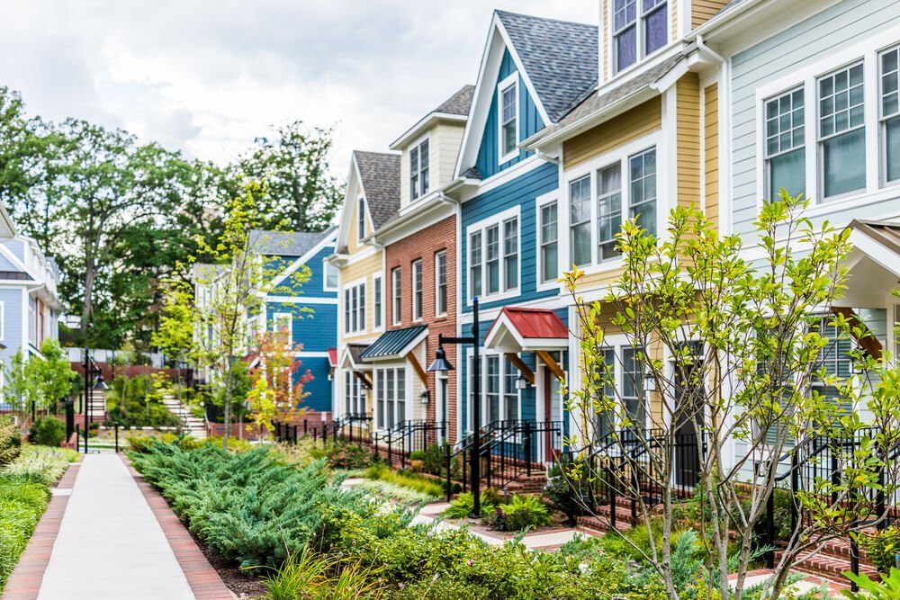 A row of colorful homes with nice, green landscaping.