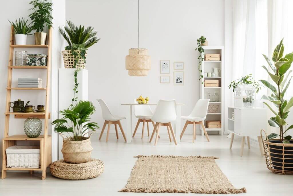 A beautiful white room filled with greenery and light wood furnishings.