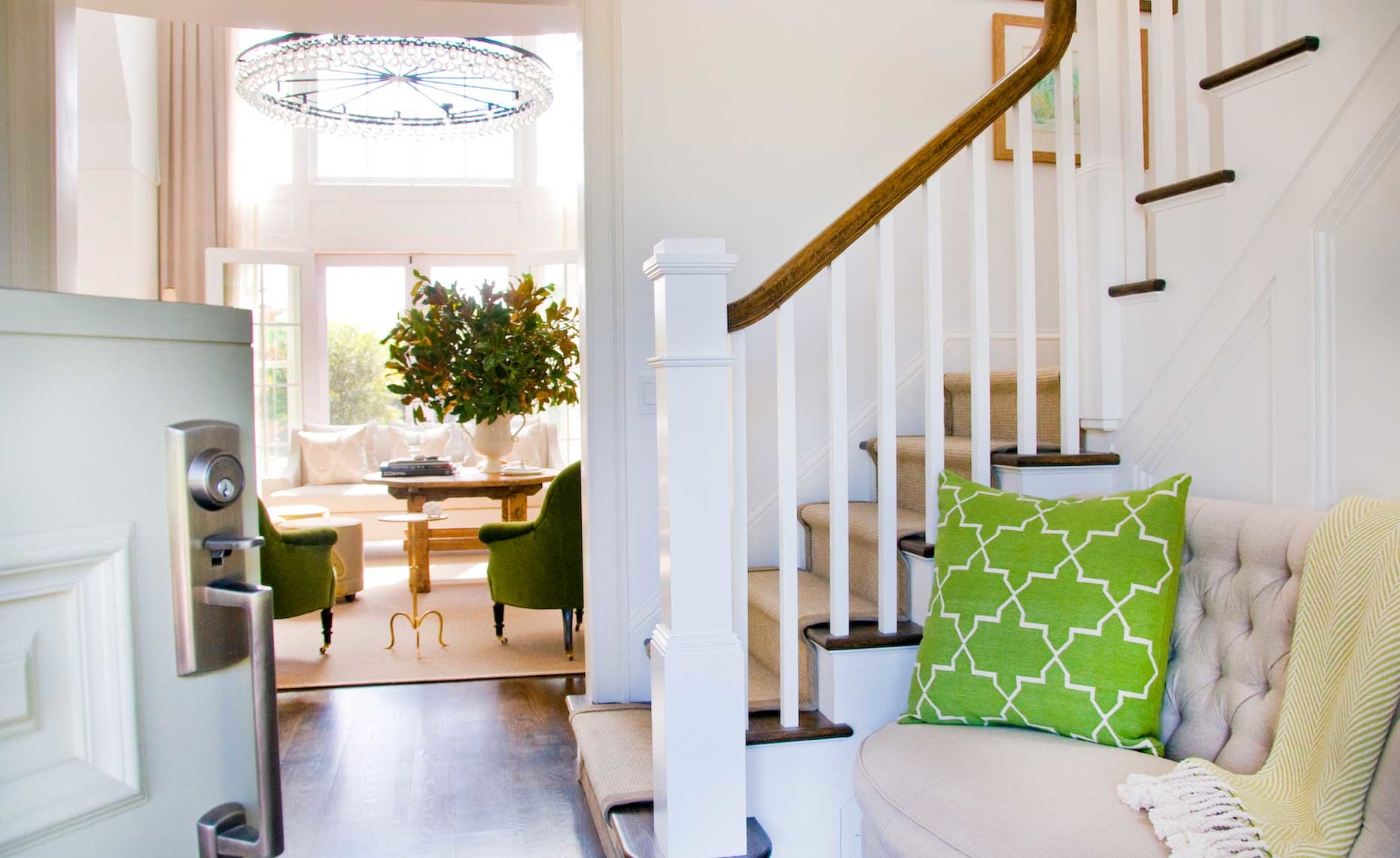 A beautiful, updated living room with a clean, white staircase and modern decor.