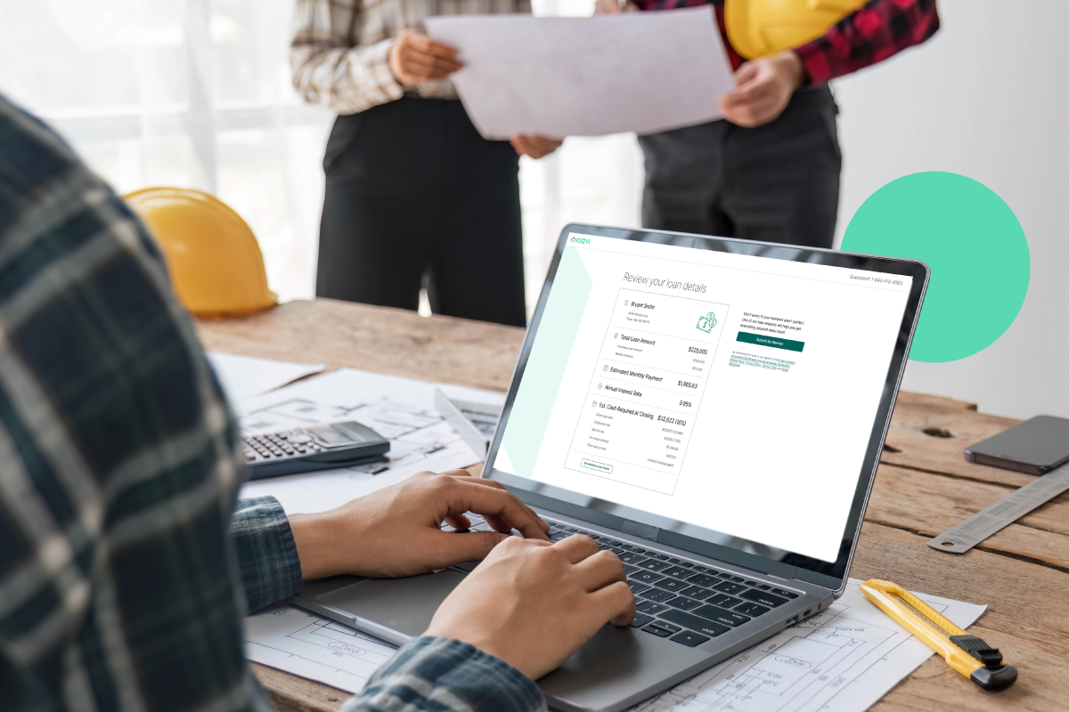 A real estate investor using Kiavi’s platform on a laptop at a wooden table, reviewing loan details with plans and tools nearby.