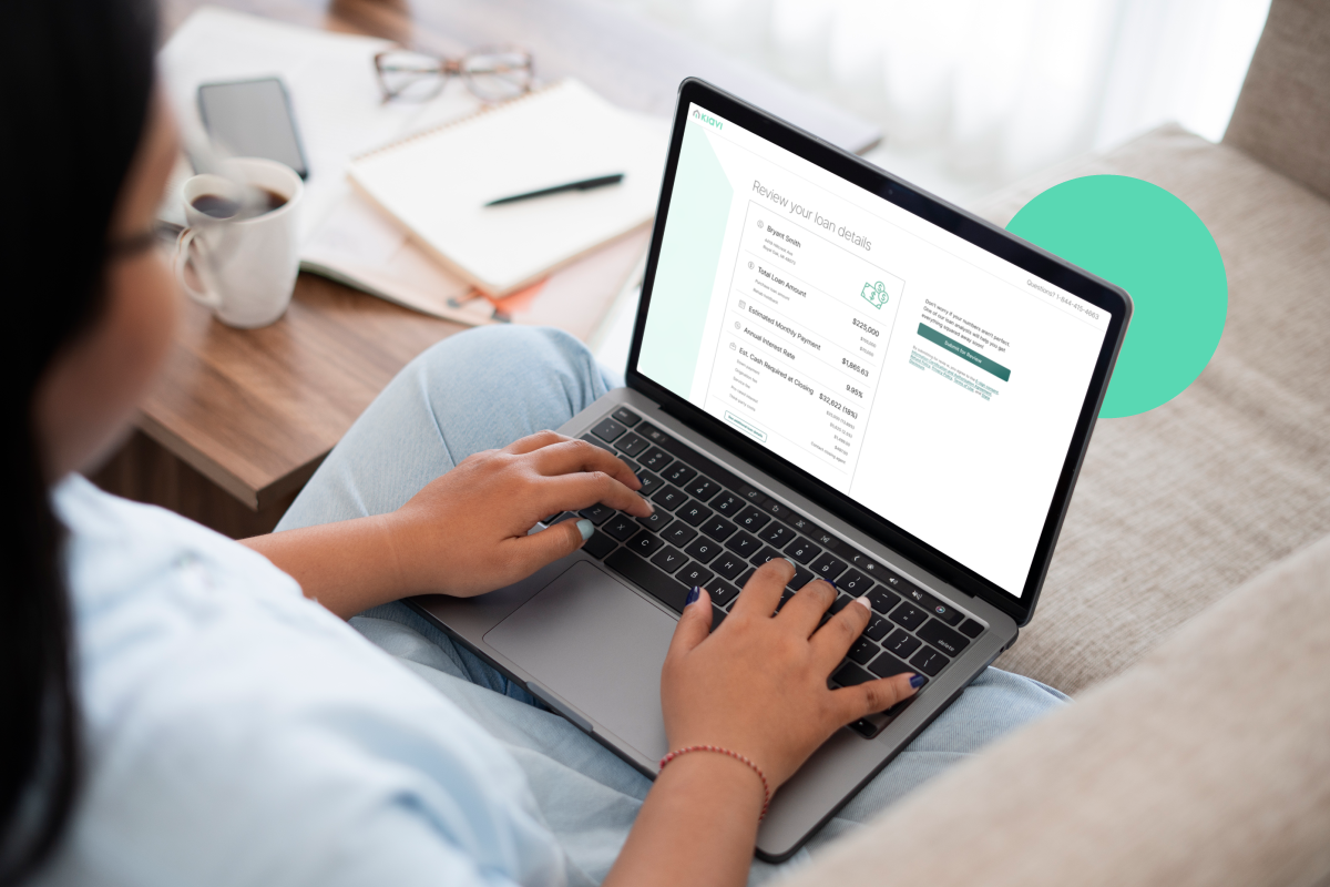 A Kiavi real estate investor reviewing a portfolio loan on a laptop while seated on a couch.