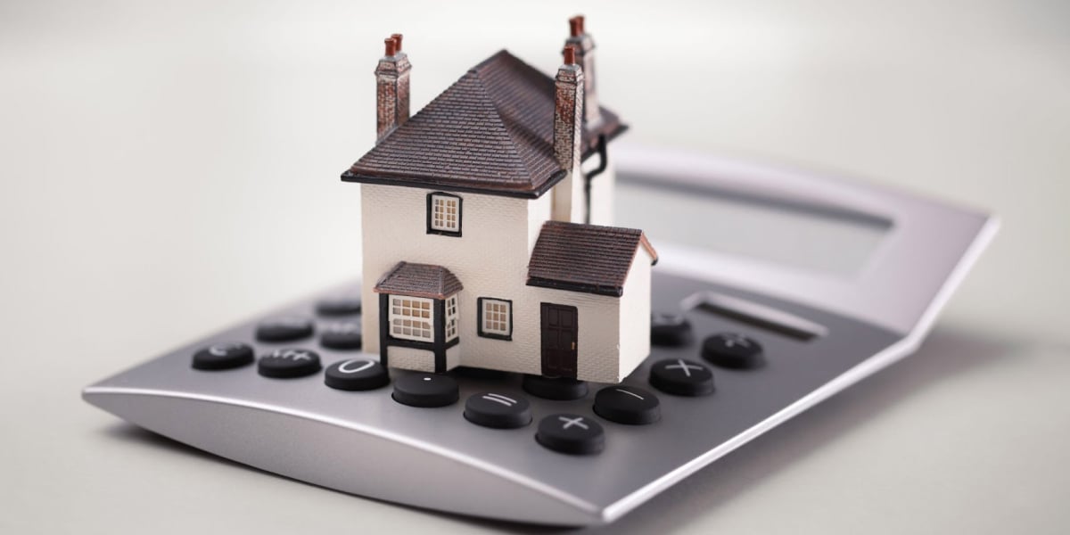 tiny model home on top of a calculator