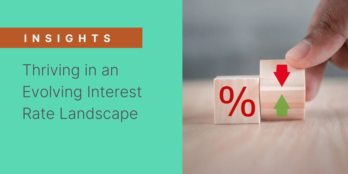 Banner for 'Insights' article titled 'Thriving in an Evolving Interest Rate Landscape,' featuring a hand adjusting wooden blocks with percentage symbols and arrows indicating fluctuating interest rates.