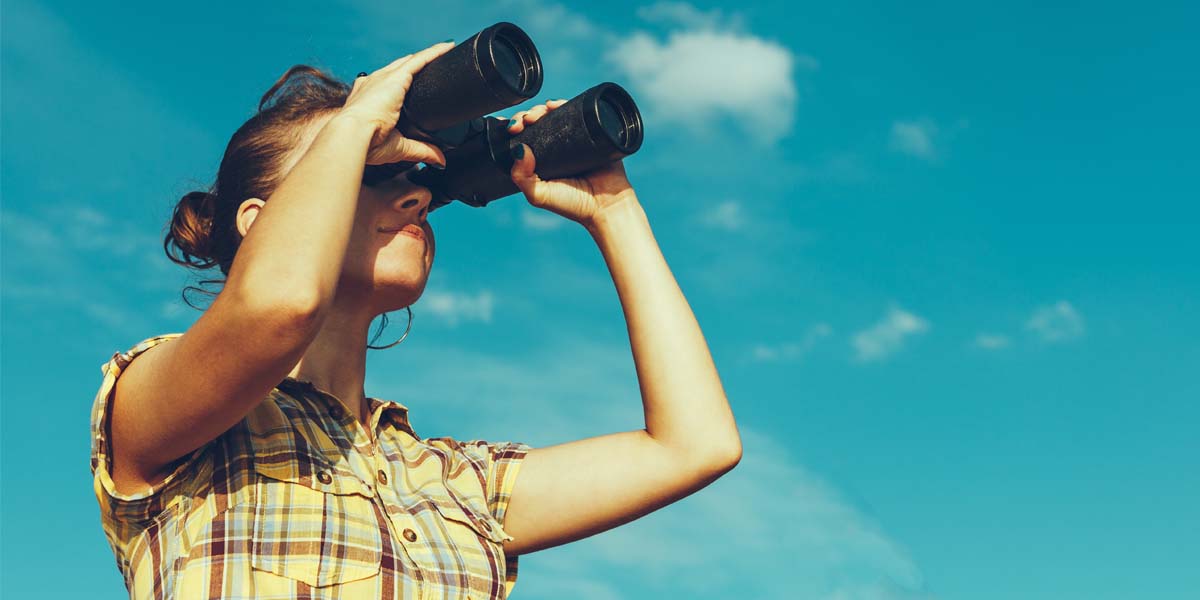 real estate investor looking through binoculars