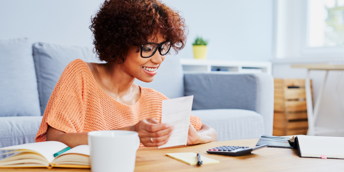 smiling real estate agent sitting at a table with a calculator