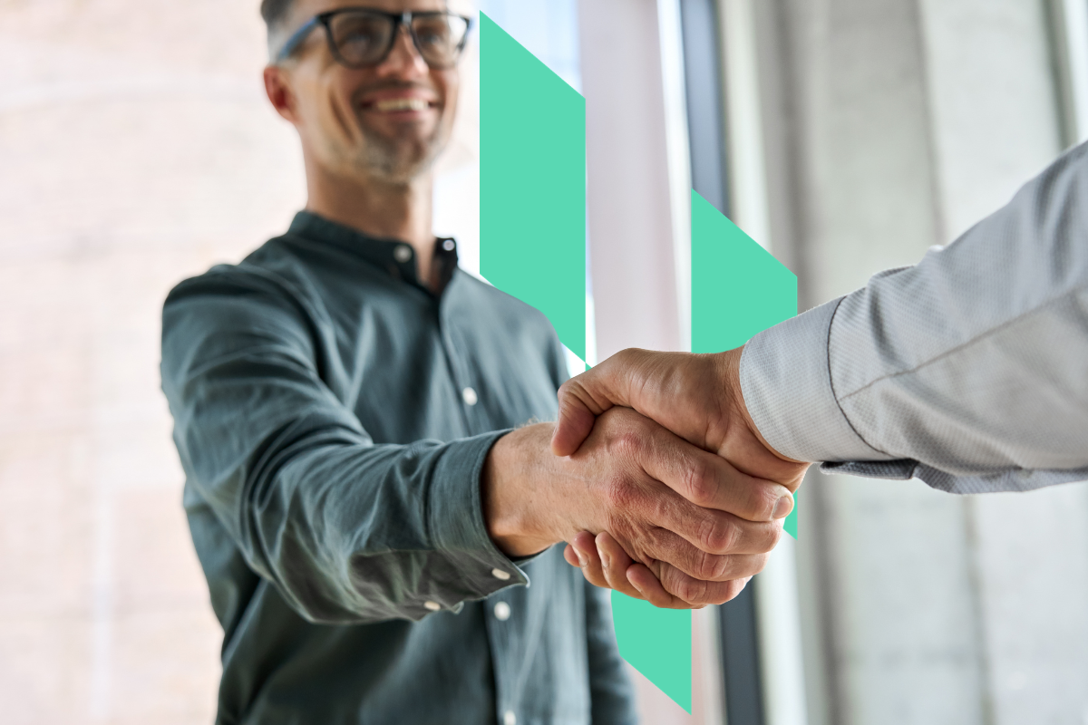 Two professionals shaking hands to symbolize a strategic real estate investing partnership with Kiavi.