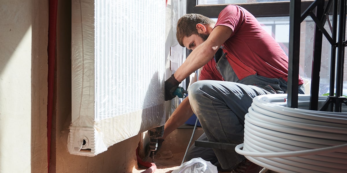 A man in a red shirt working on renovations for a fix and flip property with tools