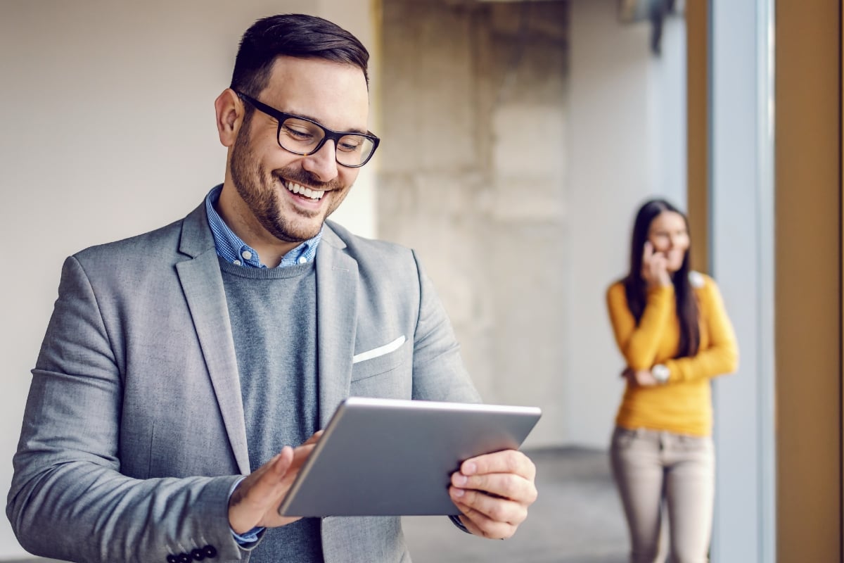 Two real estate investors reviewing Kiavi's buy-and-hold strategy from a tablet