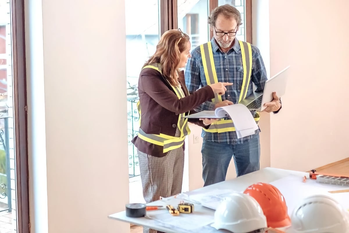 Two contractors reviewing a fix-and-flip renovation plan