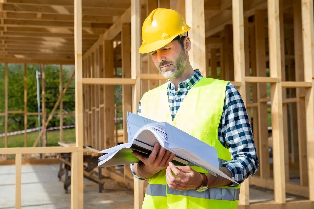 An engineer reviewing blueprints for a new construction investment property