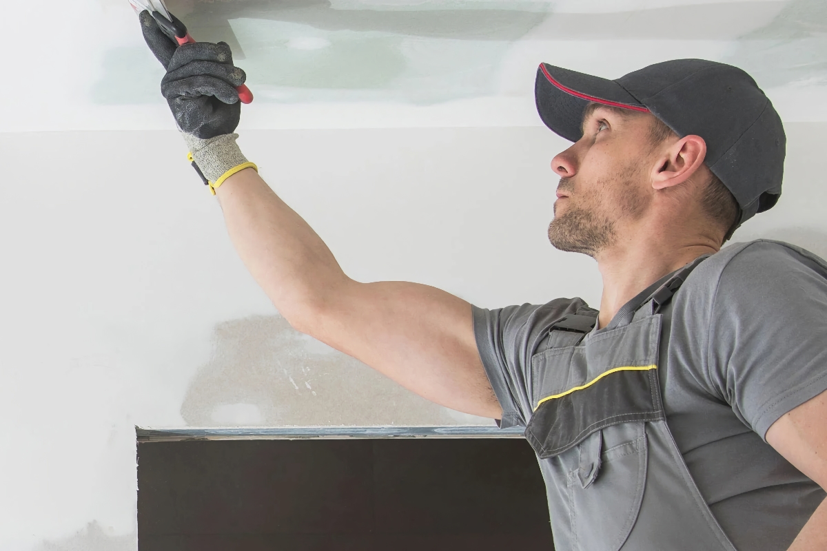 Real estate investor finishing drywall in his new fix-and-flip property