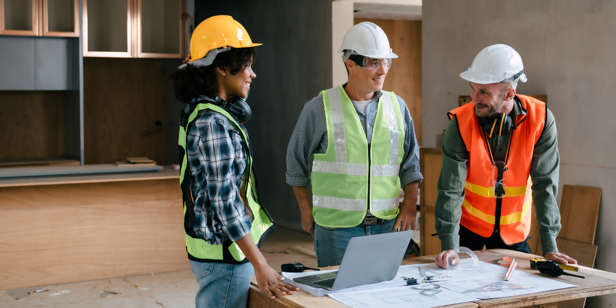 A real estate investor and two general contractors review new construction plans using Kiavi real estate financing.
