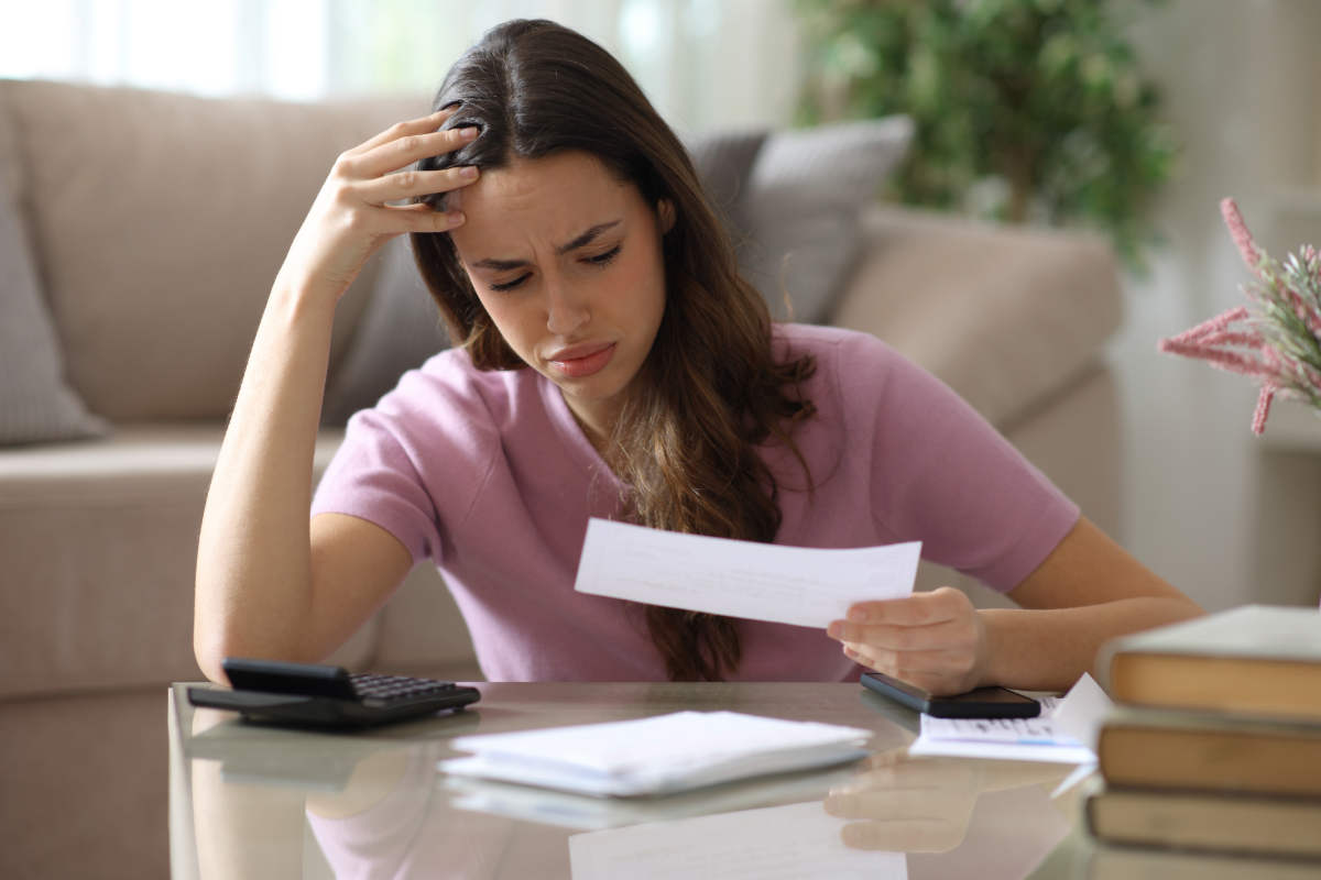Stressed real estate investor reviewing loan payment paperwork before applying for Kiavi bridge loans.
